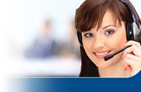 Customer service representative wearing a headset and smiling, with a blurred office background