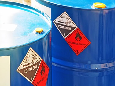 two large blue containers of corrosive flammable liquid chemicals